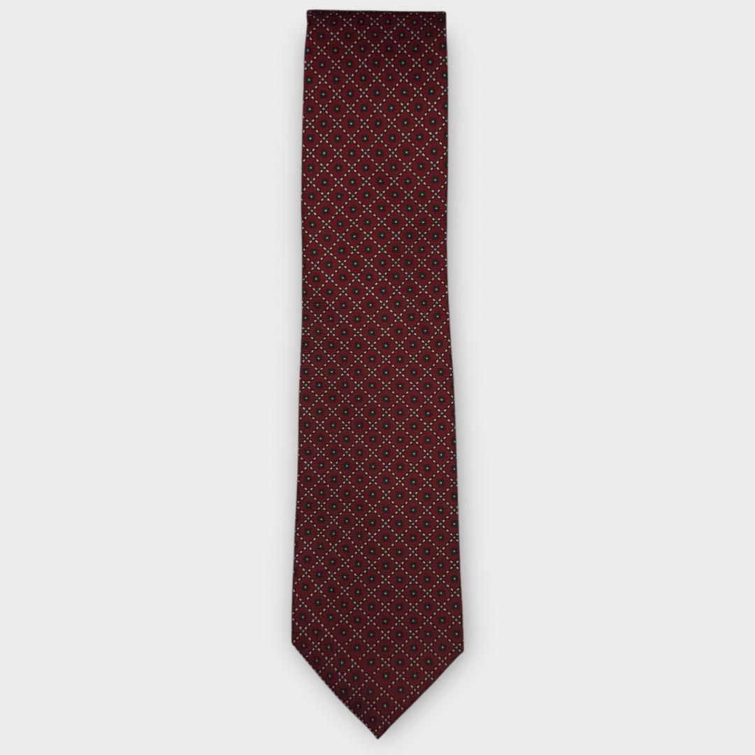 Classic silk necktie, printed in England, with a 9cm blade and 150cm length, laid flat against a plain background
