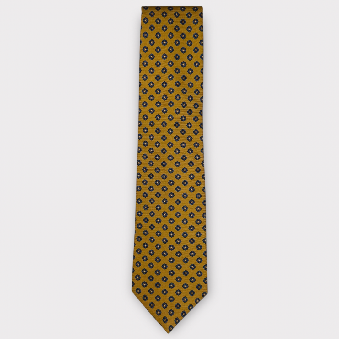 Classic silk necktie, printed in England, with a 9cm blade and 150cm length, laid flat against a plain background